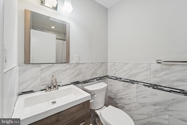 bathroom with vanity, toilet, tile walls, and curtained shower