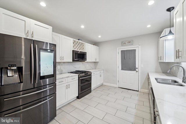 kitchen featuring light stone countertops, sink, hanging light fixtures, white cabinets, and appliances with stainless steel finishes