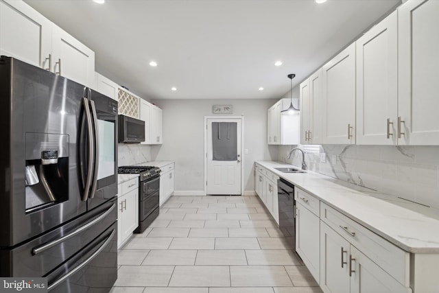 kitchen with white cabinets, sink, light stone countertops, and black appliances