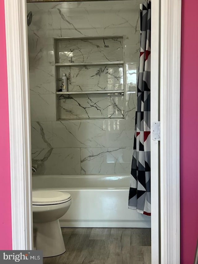 bathroom featuring shower / bath combo, hardwood / wood-style flooring, and toilet