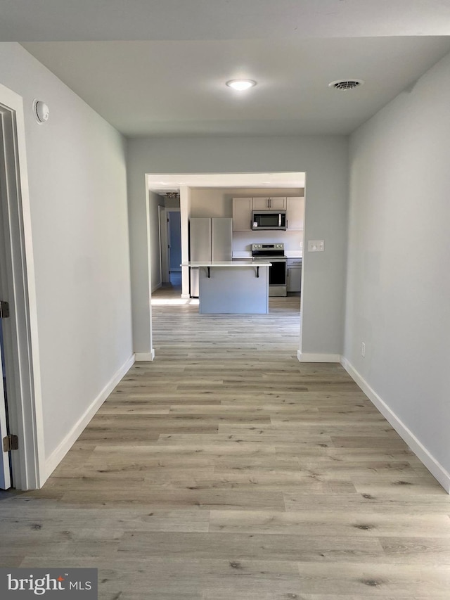 corridor with light hardwood / wood-style floors