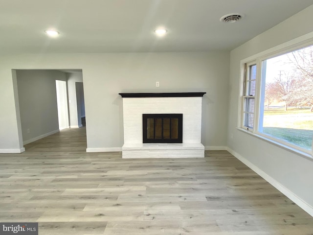 unfurnished living room with a fireplace and light hardwood / wood-style flooring