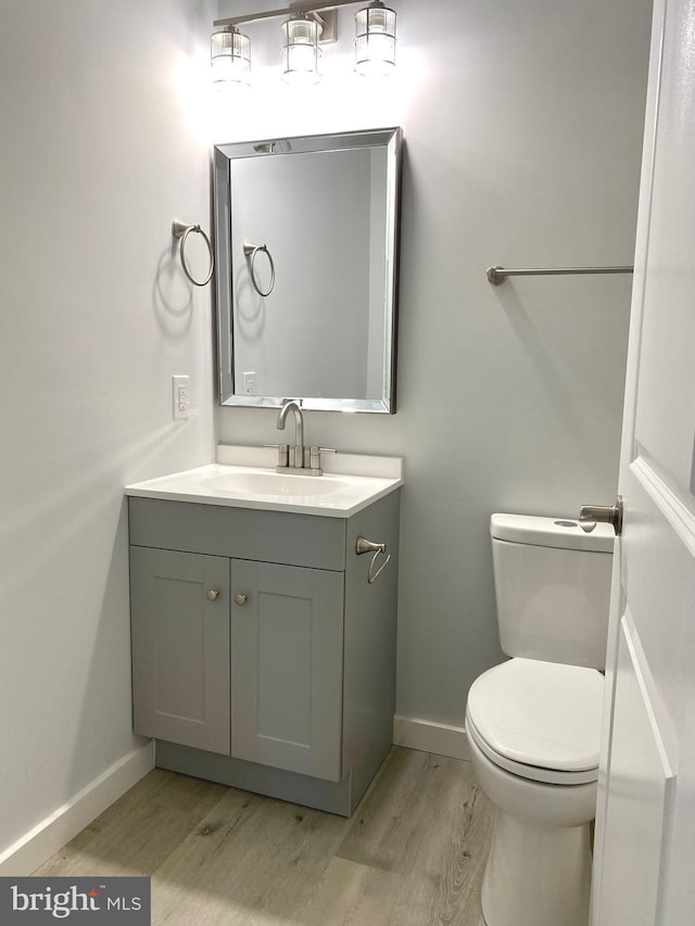 bathroom featuring toilet, vanity, and hardwood / wood-style flooring