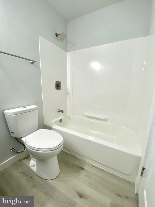 bathroom featuring toilet, shower / bathing tub combination, and hardwood / wood-style flooring