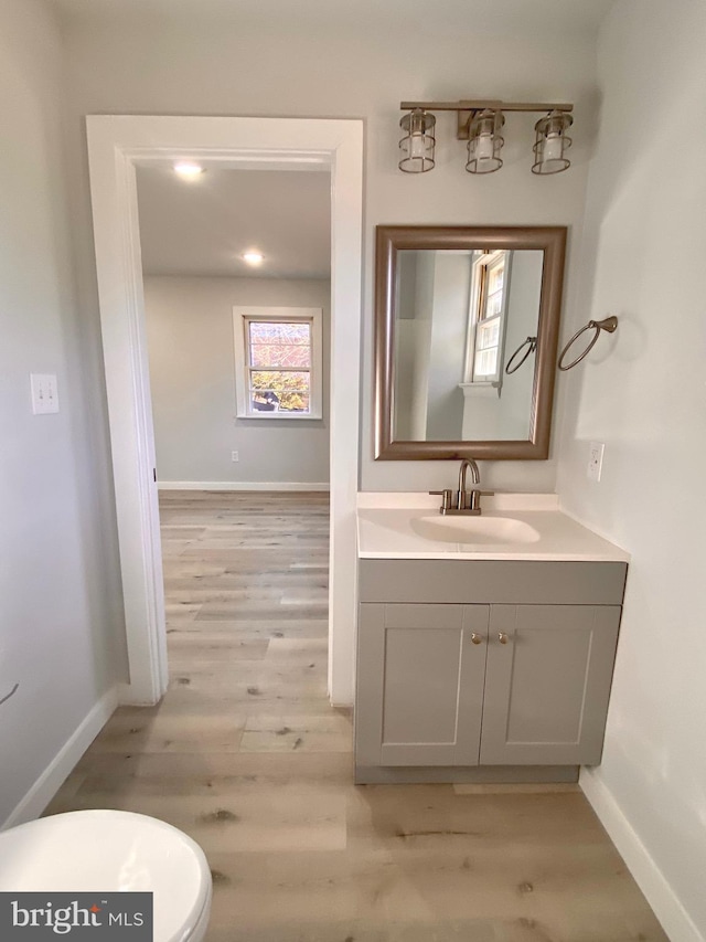 bathroom featuring hardwood / wood-style floors, vanity, and toilet