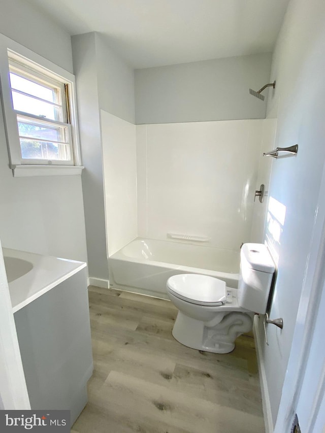 full bathroom with vanity, wood-type flooring, shower / bathtub combination, and toilet