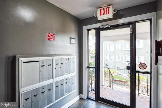 foyer entrance featuring a mail area and dark tile patterned floors