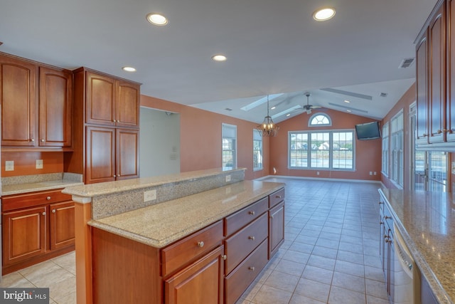 kitchen featuring lofted ceiling, ceiling fan with notable chandelier, hanging light fixtures, light stone countertops, and a kitchen island