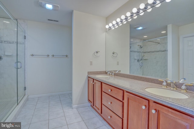 bathroom with tile patterned flooring, vanity, and walk in shower