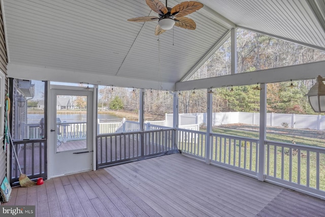 unfurnished sunroom featuring vaulted ceiling with beams, ceiling fan, and a water view