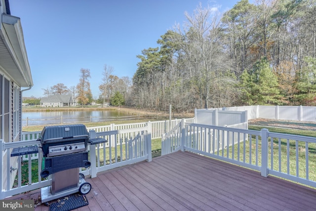 wooden deck featuring a water view, area for grilling, and a lawn