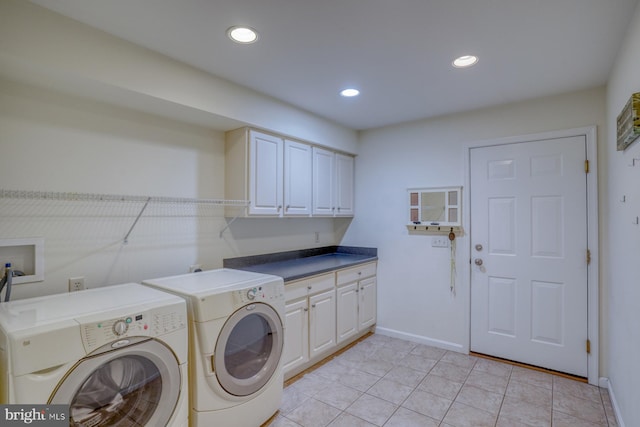 clothes washing area featuring cabinets, light tile patterned floors, and washer and dryer