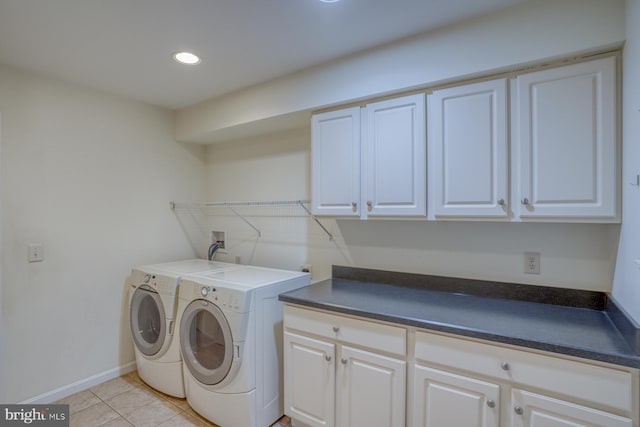 laundry room featuring washer and dryer, light tile patterned floors, and cabinets