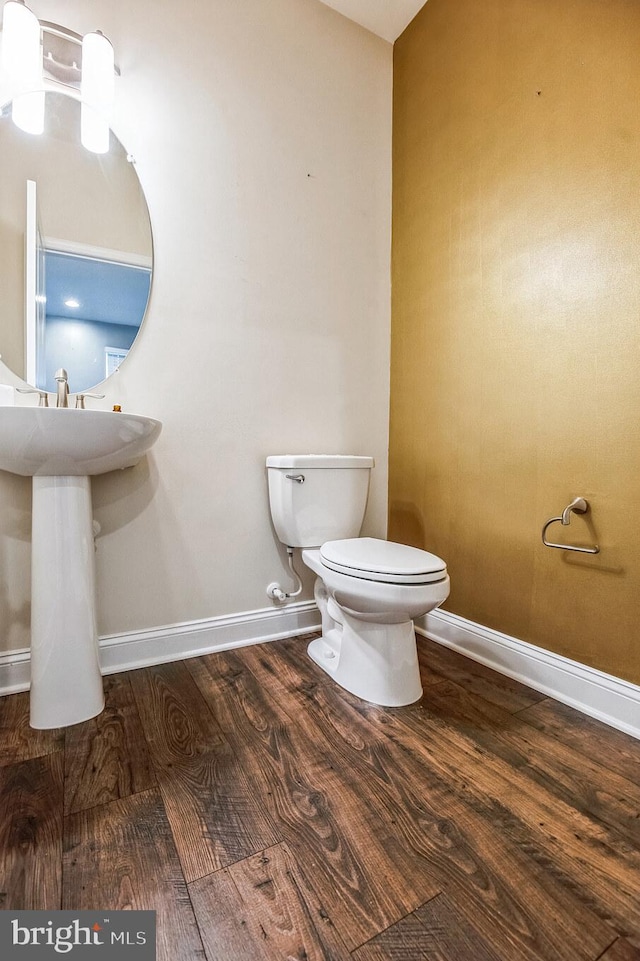 bathroom with toilet and hardwood / wood-style flooring