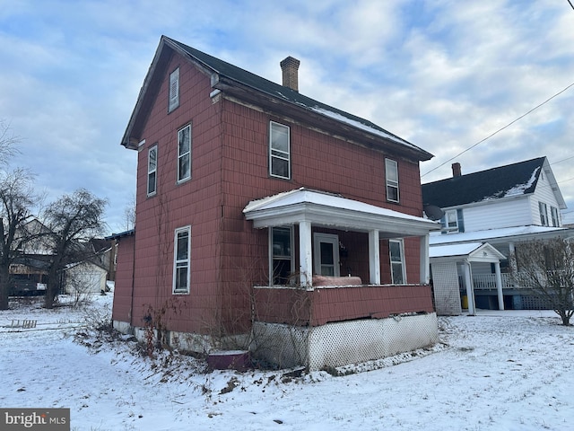 view of snowy exterior featuring a porch