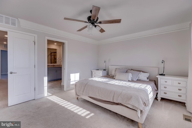 bedroom featuring ornamental molding, ceiling fan, light colored carpet, and ensuite bath