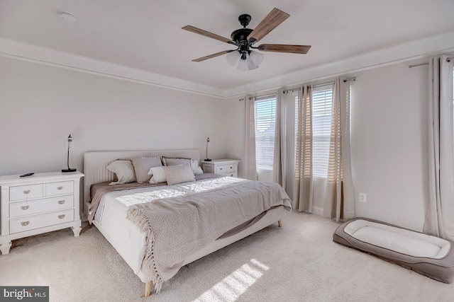 bedroom featuring crown molding, light colored carpet, and ceiling fan