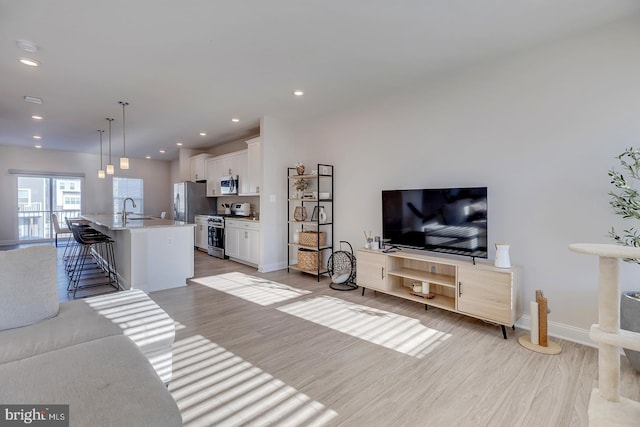 living room with sink and light hardwood / wood-style flooring