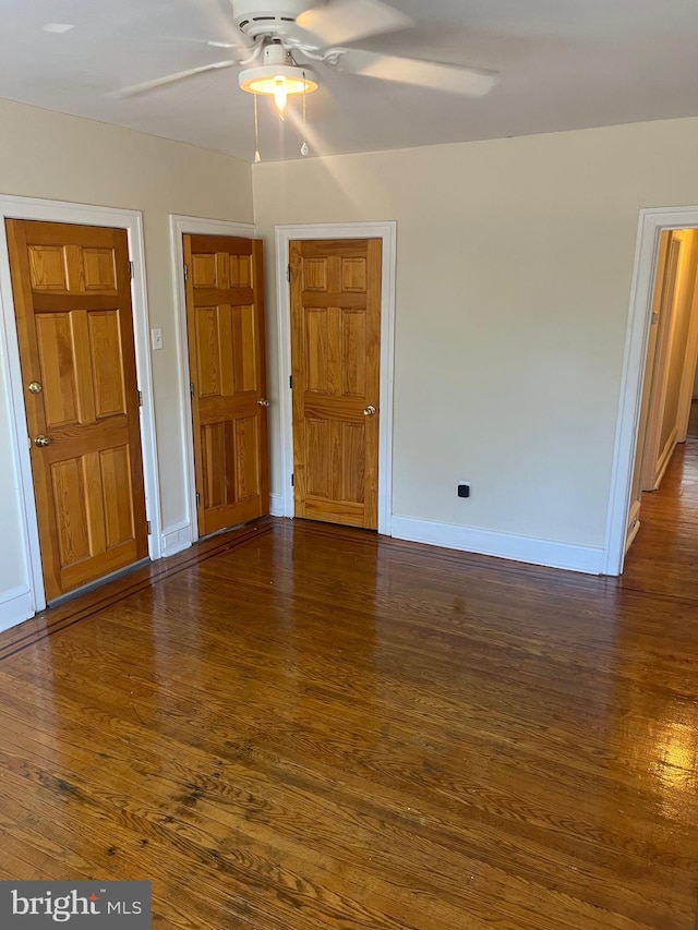 spare room featuring ceiling fan and dark wood-type flooring