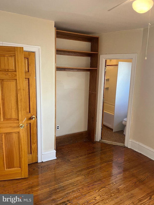 unfurnished bedroom with ceiling fan, connected bathroom, and dark hardwood / wood-style floors