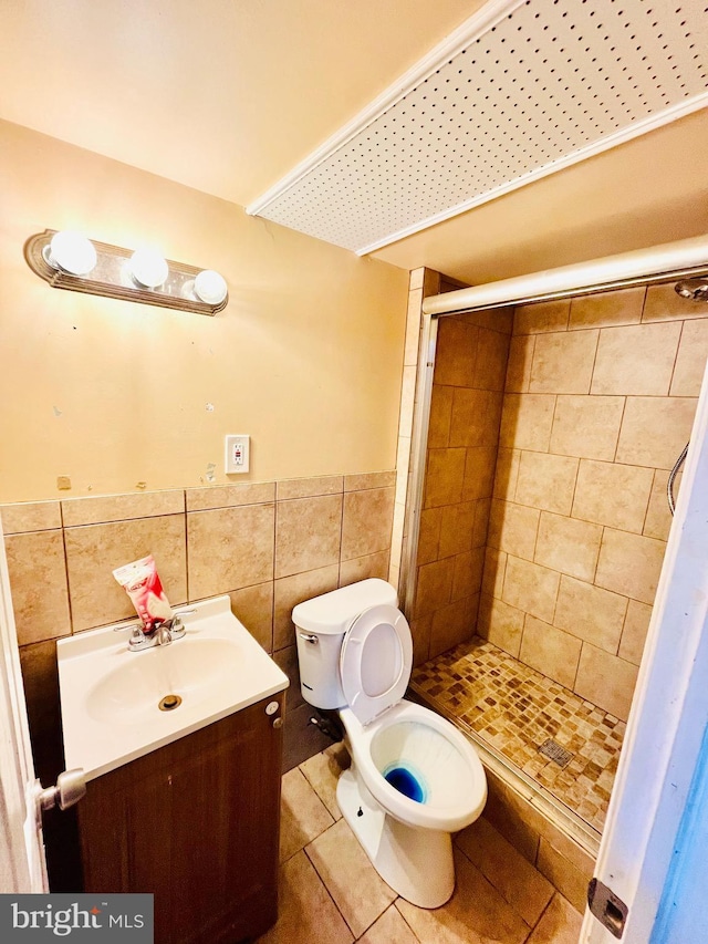 bathroom featuring toilet, walk in shower, tile walls, tile patterned floors, and vanity