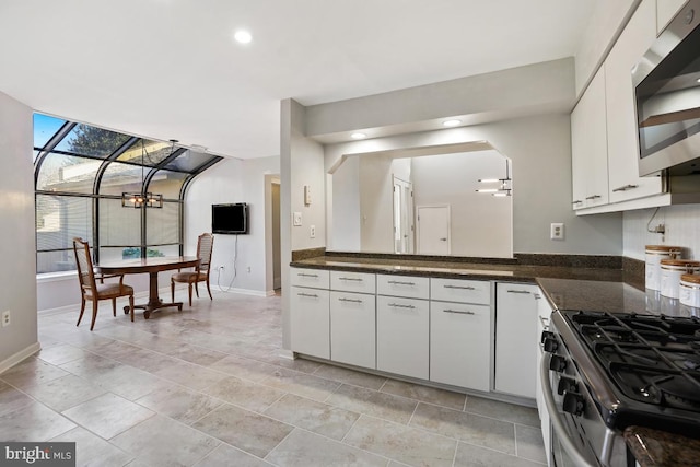 kitchen featuring recessed lighting, baseboards, white cabinets, appliances with stainless steel finishes, and dark stone countertops