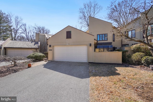 view of front of property featuring aphalt driveway, an attached garage, and stucco siding