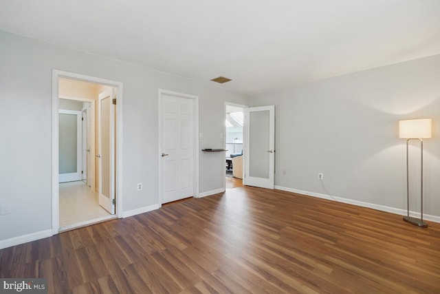 unfurnished bedroom featuring wood finished floors, visible vents, and baseboards