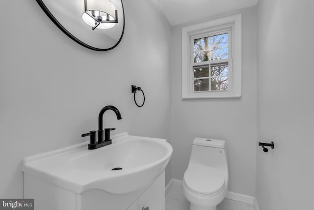 bathroom featuring vanity, toilet, and vaulted ceiling