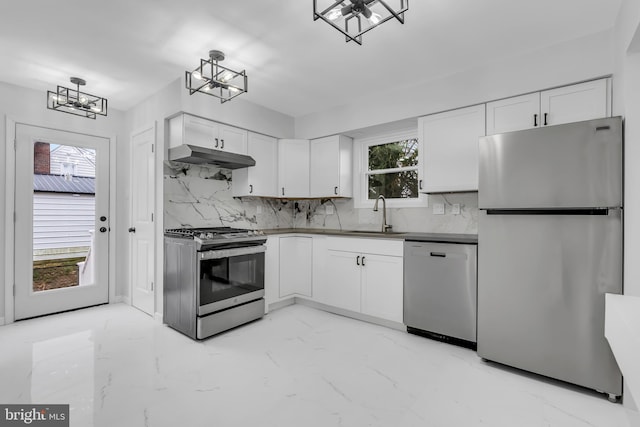 kitchen with appliances with stainless steel finishes, backsplash, white cabinetry, and sink