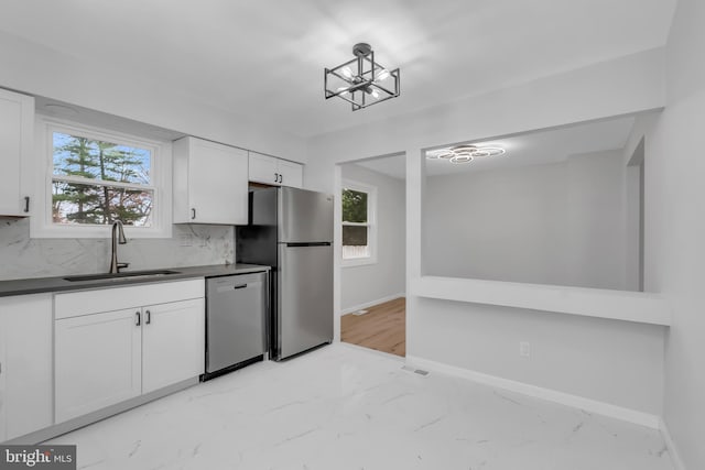 kitchen with white cabinets, sink, appliances with stainless steel finishes, tasteful backsplash, and a healthy amount of sunlight