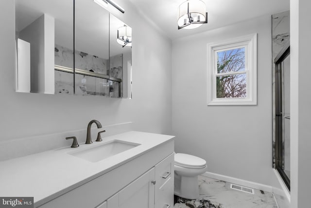 bathroom featuring a shower with door, vanity, and toilet