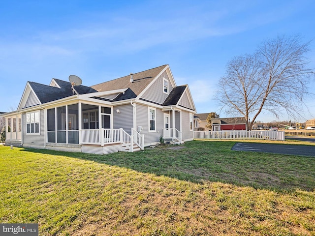 view of home's exterior with a sunroom and a yard