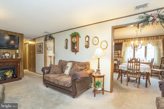 carpeted living room featuring a notable chandelier, a large fireplace, and crown molding