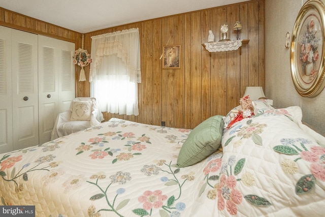 bedroom with a closet and wooden walls