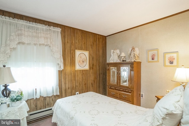 bedroom with baseboard heating, wooden walls, and ornamental molding