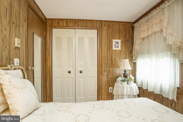 bedroom with wood walls, ornamental molding, and a closet