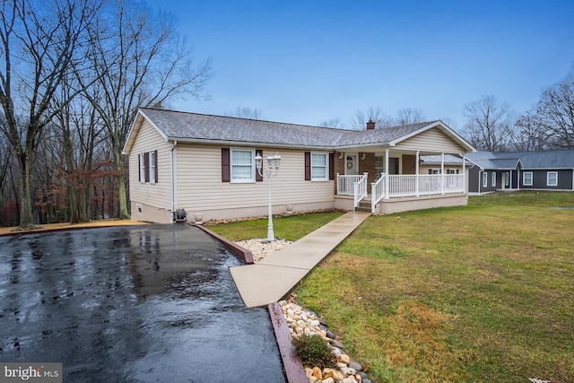 single story home with covered porch and a front yard