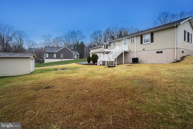 back of house featuring an outdoor structure, a yard, and central air condition unit