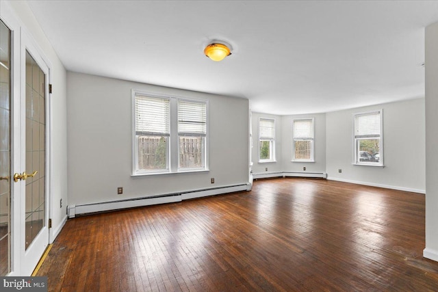 unfurnished living room featuring plenty of natural light, dark hardwood / wood-style floors, and a baseboard heating unit