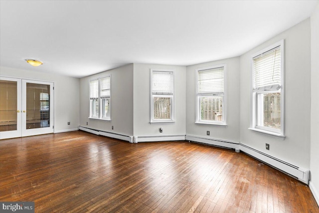 spare room with baseboard heating, dark hardwood / wood-style flooring, and french doors