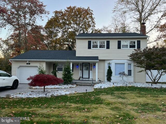 view of property with a garage and a front yard