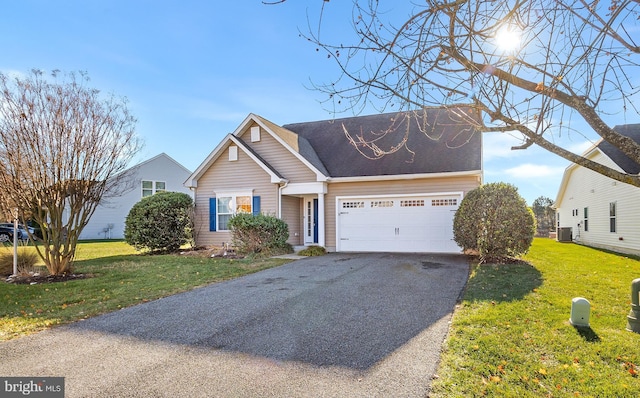 view of front facade featuring a front yard, a garage, and central AC unit