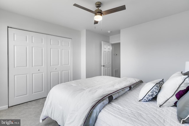 bedroom featuring ceiling fan, a closet, and light carpet