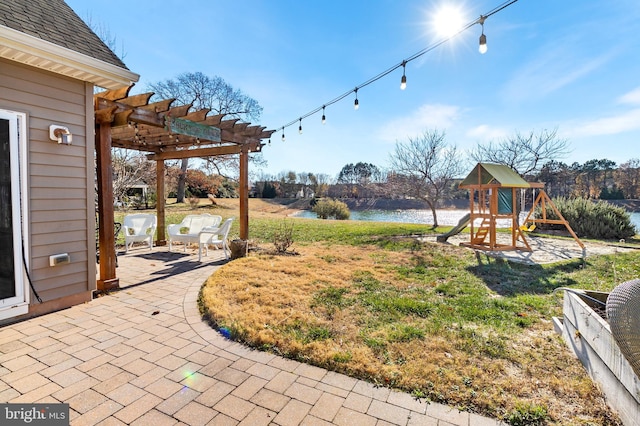 view of yard featuring a pergola, a patio area, a playground, and a water view