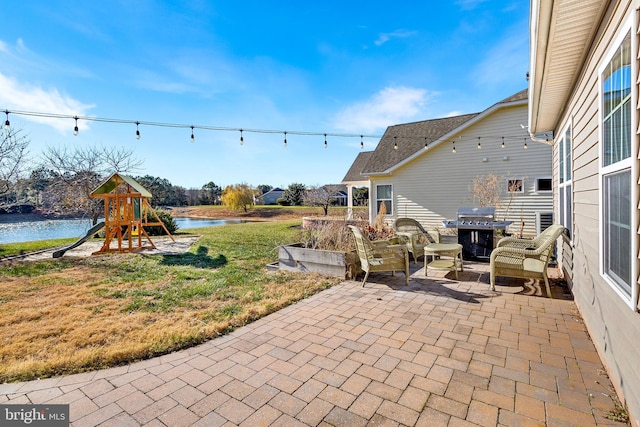 view of patio with a playground, a grill, and a water view