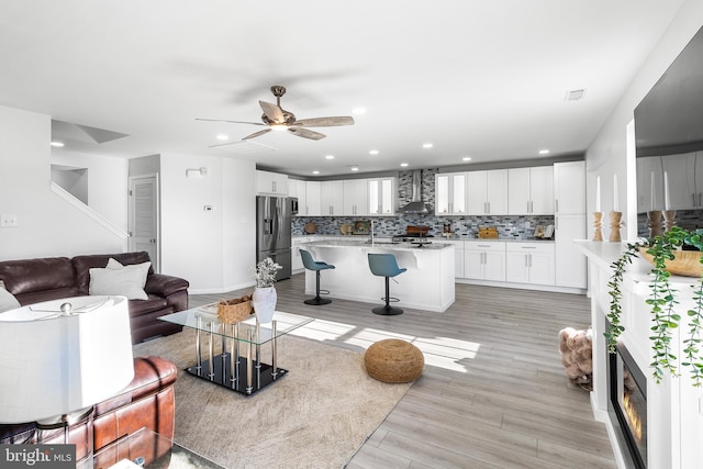 living room featuring ceiling fan and light hardwood / wood-style flooring