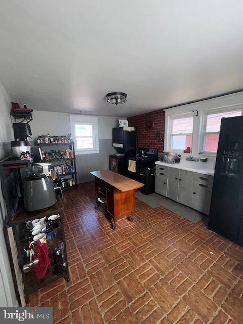 kitchen with black refrigerator with ice dispenser