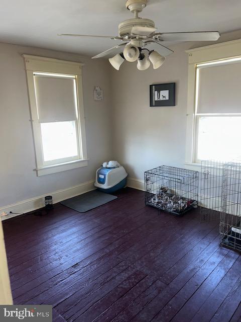 spare room with dark hardwood / wood-style floors and ceiling fan