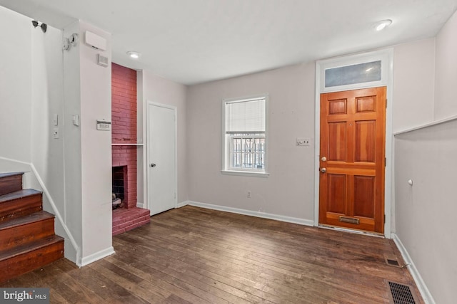 entrance foyer with a fireplace and dark hardwood / wood-style flooring